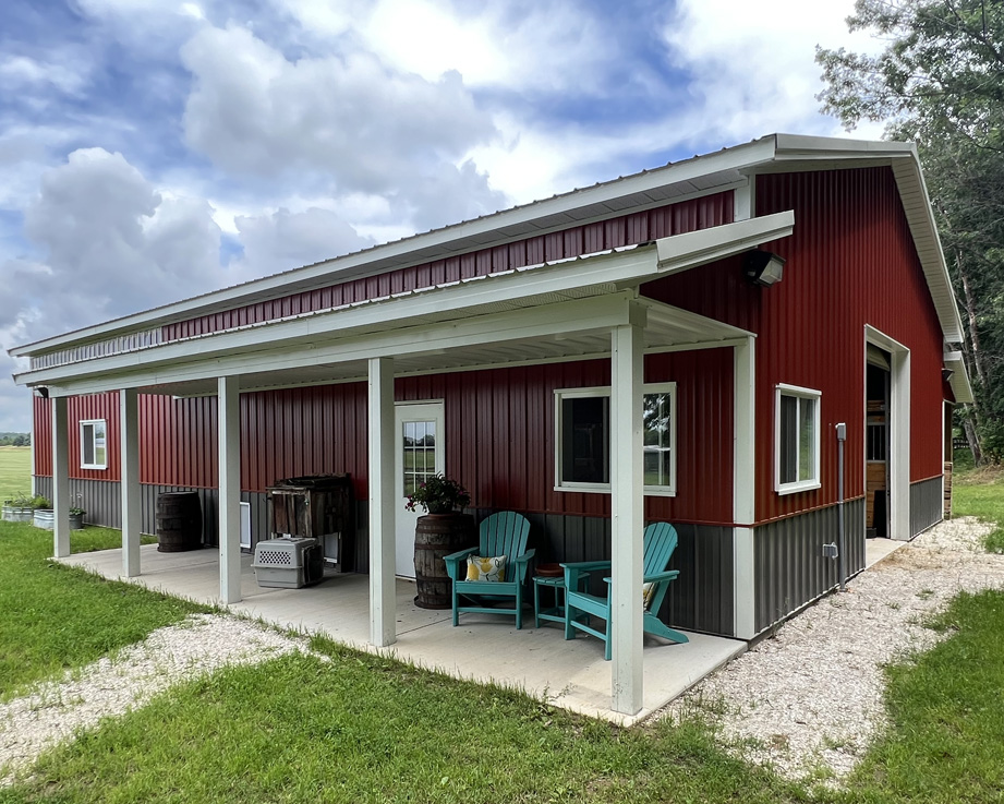 barndominium shop home with red paint and outside seating